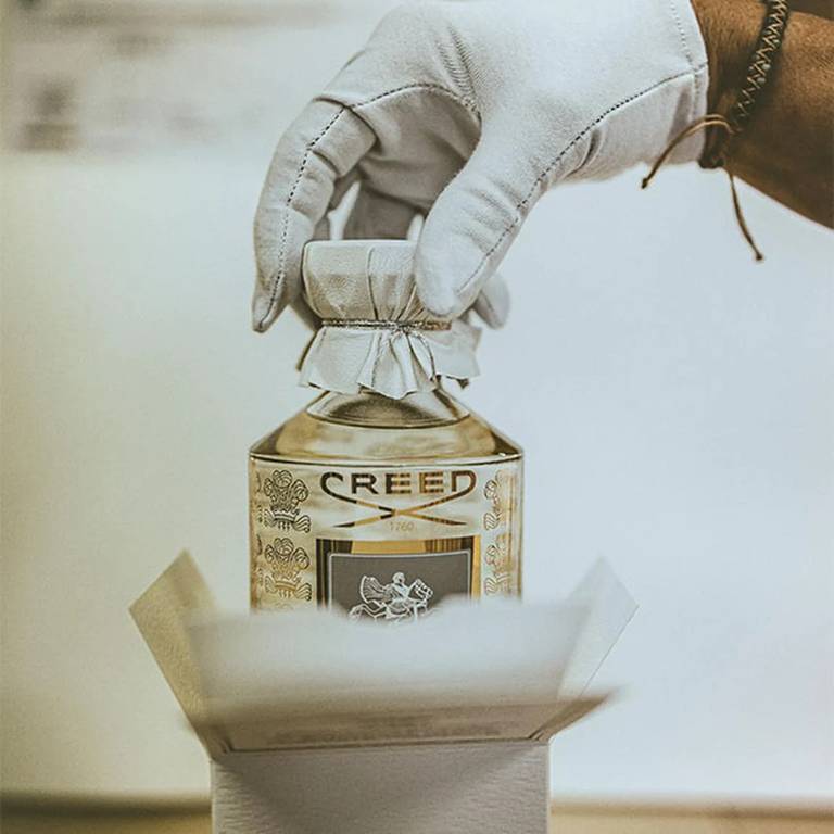 A flacon being placed in a box with a gloved hand A flacon being placed in a box with a gloved hand
